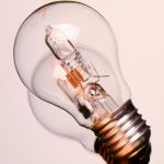Hand holding light bulb outside